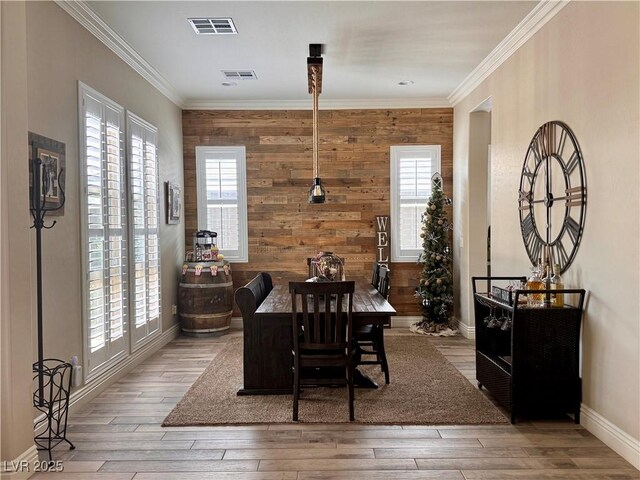 dining space featuring crown molding, visible vents, and a healthy amount of sunlight