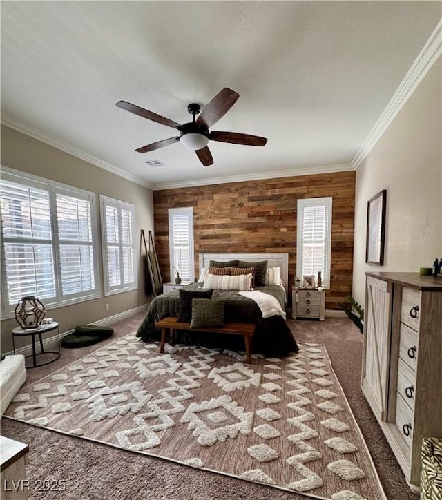 bedroom with wooden walls, dark colored carpet, ornamental molding, and visible vents