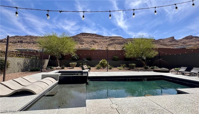 view of pool featuring a mountain view and a fenced backyard