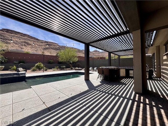 view of patio / terrace with a mountain view, a fenced backyard, and a fenced in pool