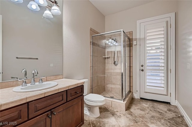 bathroom featuring toilet, a stall shower, and vanity