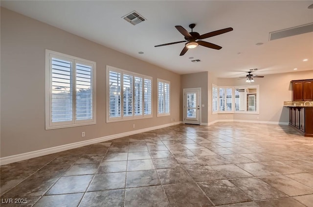 unfurnished living room with ceiling fan, baseboards, visible vents, and recessed lighting