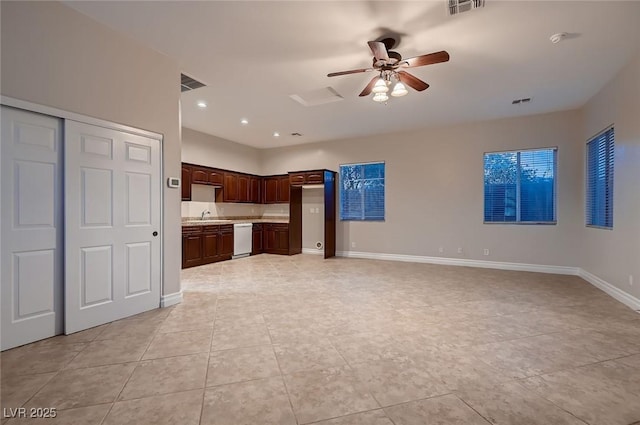 unfurnished living room with ceiling fan, visible vents, light tile patterned flooring, a sink, and baseboards