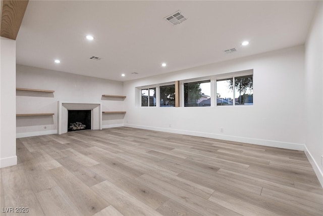 unfurnished living room featuring light wood-style flooring, baseboards, visible vents, and recessed lighting