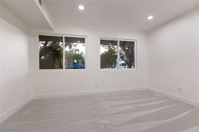 spare room featuring recessed lighting, carpet, and baseboards