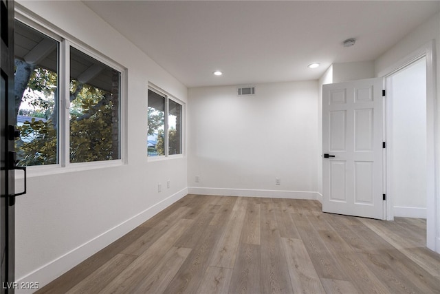 empty room with recessed lighting, visible vents, light wood-type flooring, and baseboards