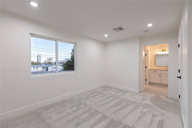 spare room featuring light colored carpet, baseboards, visible vents, and recessed lighting