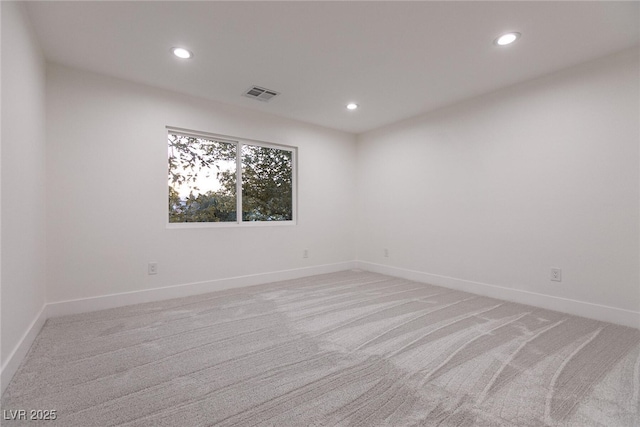 spare room with light carpet, recessed lighting, visible vents, and baseboards