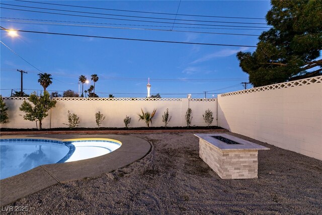 view of swimming pool with an outdoor fire pit, a fenced backyard, and a fenced in pool