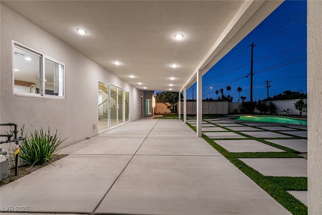 view of patio with a fenced backyard, an outdoor structure, a fenced in pool, and a storage unit