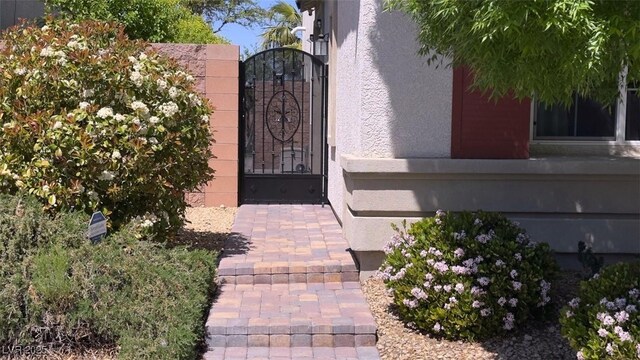 property entrance with a gate and stucco siding