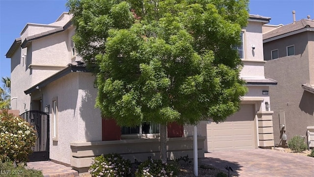 view of front of property with an attached garage, decorative driveway, and stucco siding