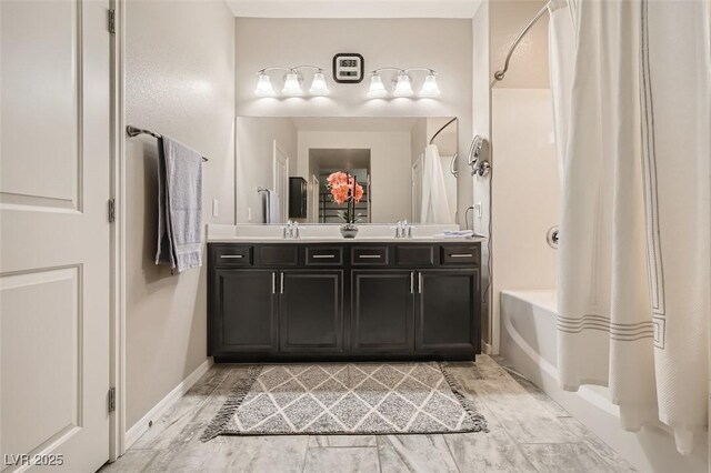 full bathroom with double vanity, shower / bathtub combination with curtain, and baseboards