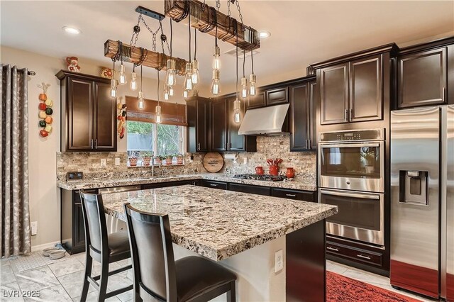 kitchen featuring stainless steel appliances, under cabinet range hood, dark brown cabinetry, decorative backsplash, and recessed lighting