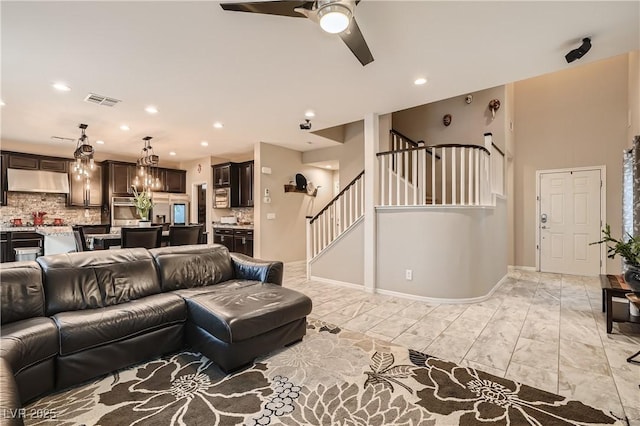 living area with stairs, a ceiling fan, recessed lighting, and baseboards