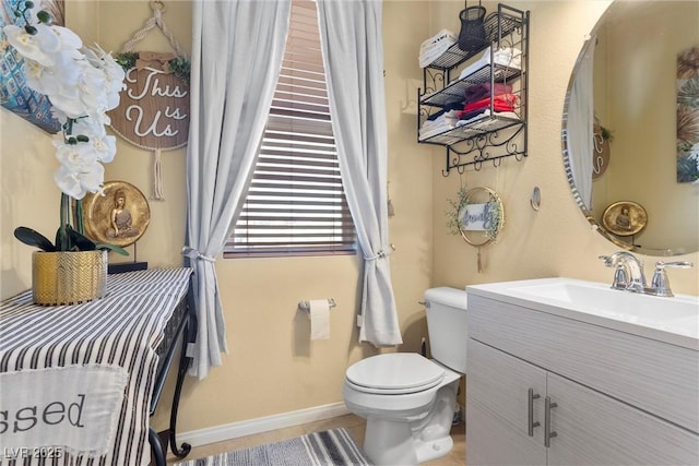 bathroom featuring toilet, tile patterned floors, vanity, and baseboards