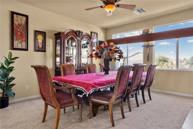 dining area featuring light carpet, baseboards, a ceiling fan, and visible vents