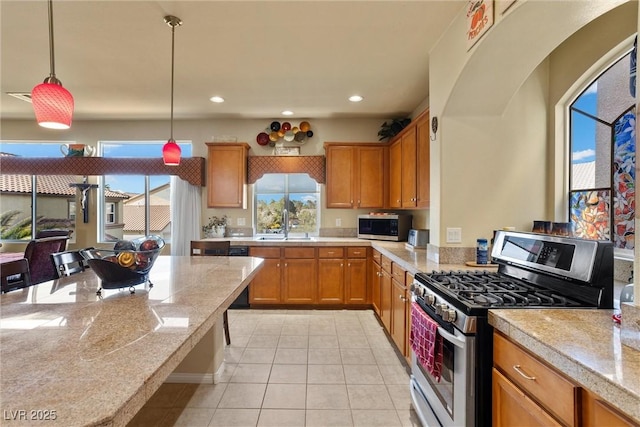 kitchen with recessed lighting, light tile patterned floors, brown cabinets, appliances with stainless steel finishes, and hanging light fixtures