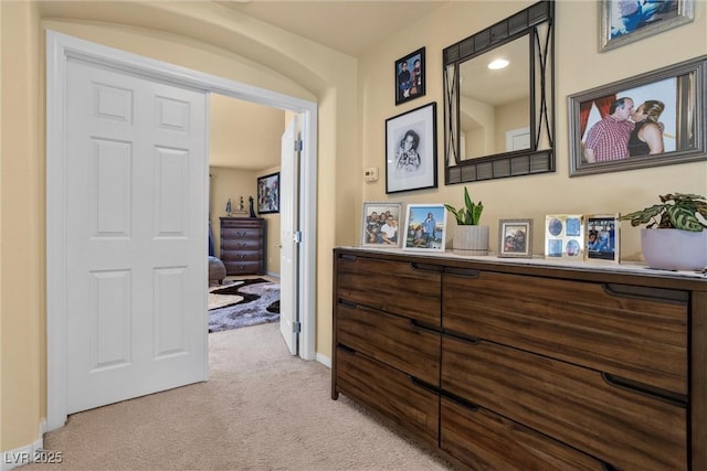hall featuring light carpet and baseboards