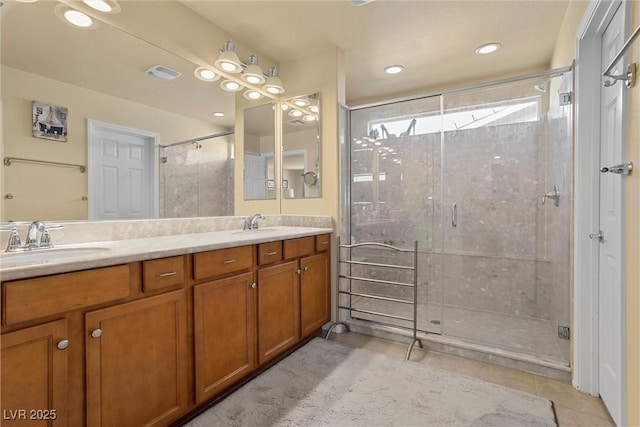 bathroom with a shower stall, tile patterned flooring, visible vents, a sink, and double vanity