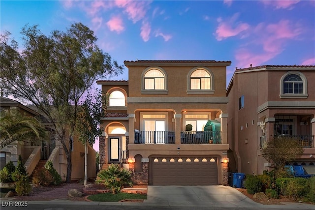 mediterranean / spanish-style house featuring a garage, driveway, stucco siding, and a tile roof