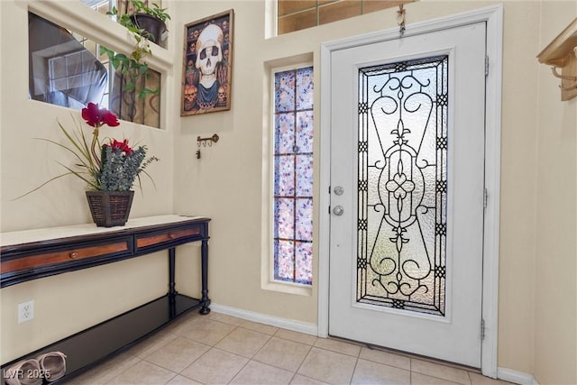 foyer entrance with light tile patterned floors and baseboards
