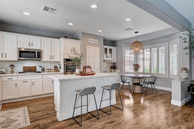 11342 Early Sun Ct, Las Vegas, NV 89135 - kitchen with baseboards, white cabinetry, visible vents, and stainless steel appliances