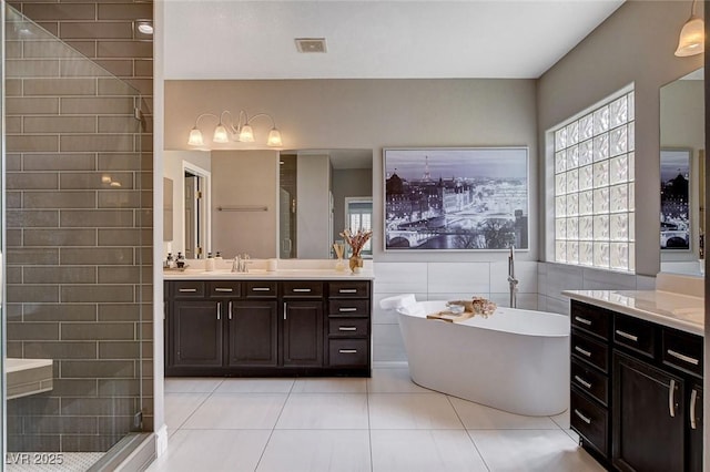 11342 Early Sun Ct, Las Vegas, NV 89135 - bathroom featuring a soaking tub, tile patterned floors, a shower stall, visible vents, and tile walls