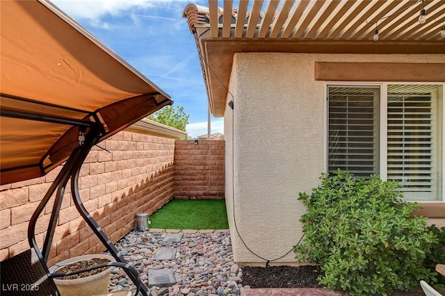11342 Early Sun Ct, Las Vegas, NV 89135 - view of side of home featuring a patio, stucco siding, and fence