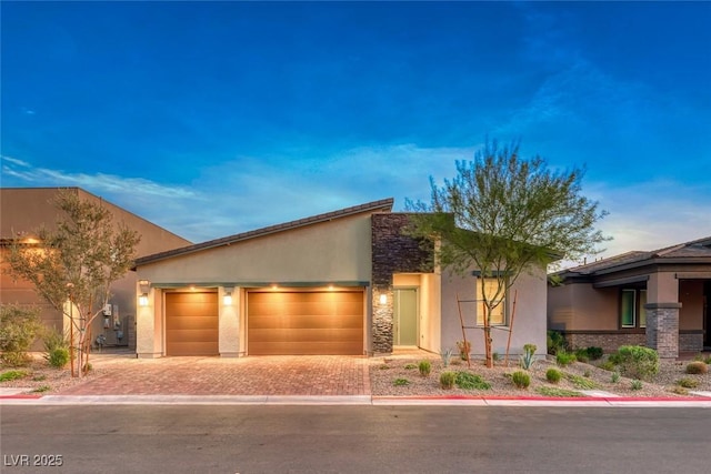 93 Reverie Heights Ave, Henderson, NV 89011 - view of front of house with driveway, stucco siding, stone siding, and an attached garage