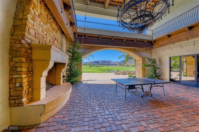93 Reverie Heights Ave, Henderson, NV 89011 - view of patio featuring outdoor dining space, exterior fireplace, and a mountain view