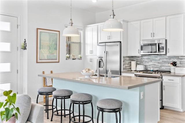 916 Belleforte Ln, Las Vegas, NV 89138 - kitchen featuring appliances with stainless steel finishes, backsplash, a breakfast bar area, and white cabinets