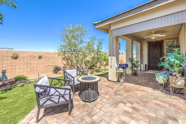 view of patio / terrace featuring ceiling fan, fence, and a fire pit