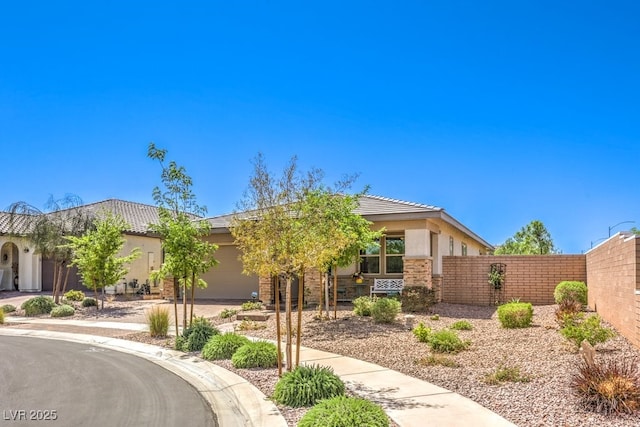 view of front of property featuring driveway, stucco siding, fence, and an attached garage