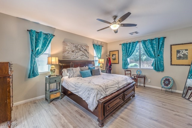 bedroom featuring light wood-style flooring, visible vents, and multiple windows