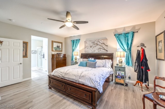 bedroom featuring ensuite bathroom, light wood-style flooring, ceiling fan, and baseboards