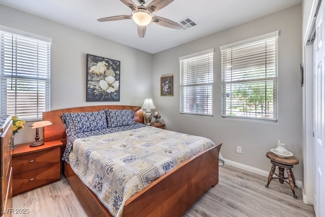 bedroom with light wood-style floors, ceiling fan, baseboards, and visible vents