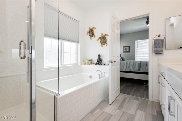 bathroom with vanity, a shower stall, ensuite bath, and a bath
