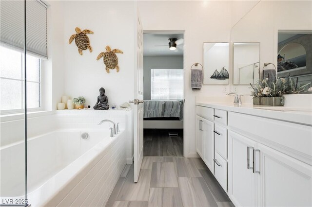 full bathroom with ensuite bathroom, a garden tub, and vanity