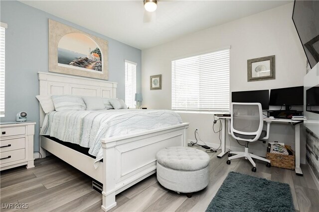 bedroom with a ceiling fan and light wood-style flooring