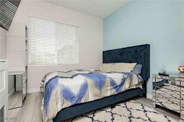 bedroom with baseboards and wood finished floors