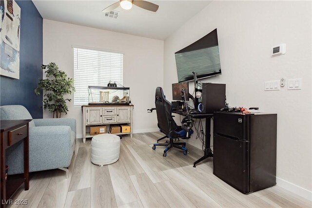 office area with baseboards, a ceiling fan, wood finished floors, and visible vents
