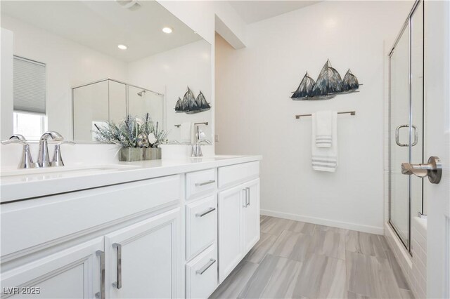 bathroom with recessed lighting, double vanity, and a stall shower
