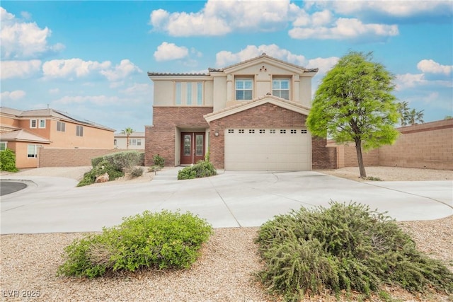 view of front of home with driveway, french doors, fence, a garage, and stucco siding