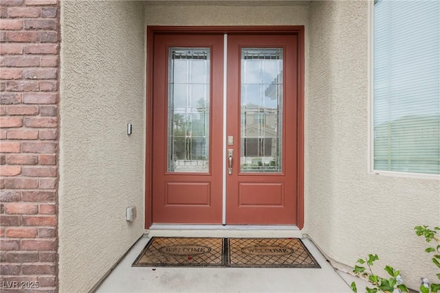 property entrance with french doors and stucco siding