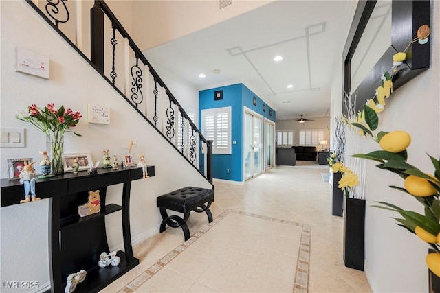 interior space featuring a ceiling fan, baseboards, recessed lighting, and stairway