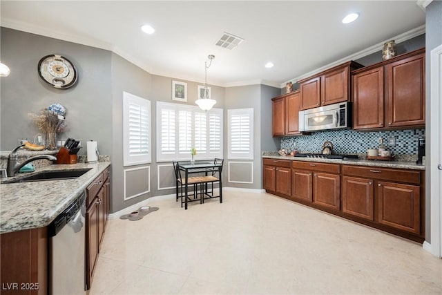 kitchen with stainless steel appliances, visible vents, a sink, pendant lighting, and decorative backsplash
