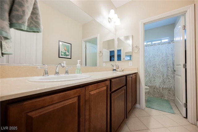 bathroom featuring tile patterned flooring, a sink, double vanity, and toilet