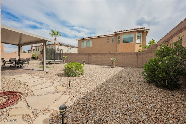 view of yard with a patio, a fenced backyard, and a trampoline
