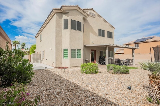back of house with stucco siding, a gate, a patio, and fence private yard